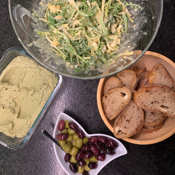Löwenzahnsalat mit Hummus, Baguette und Oliven